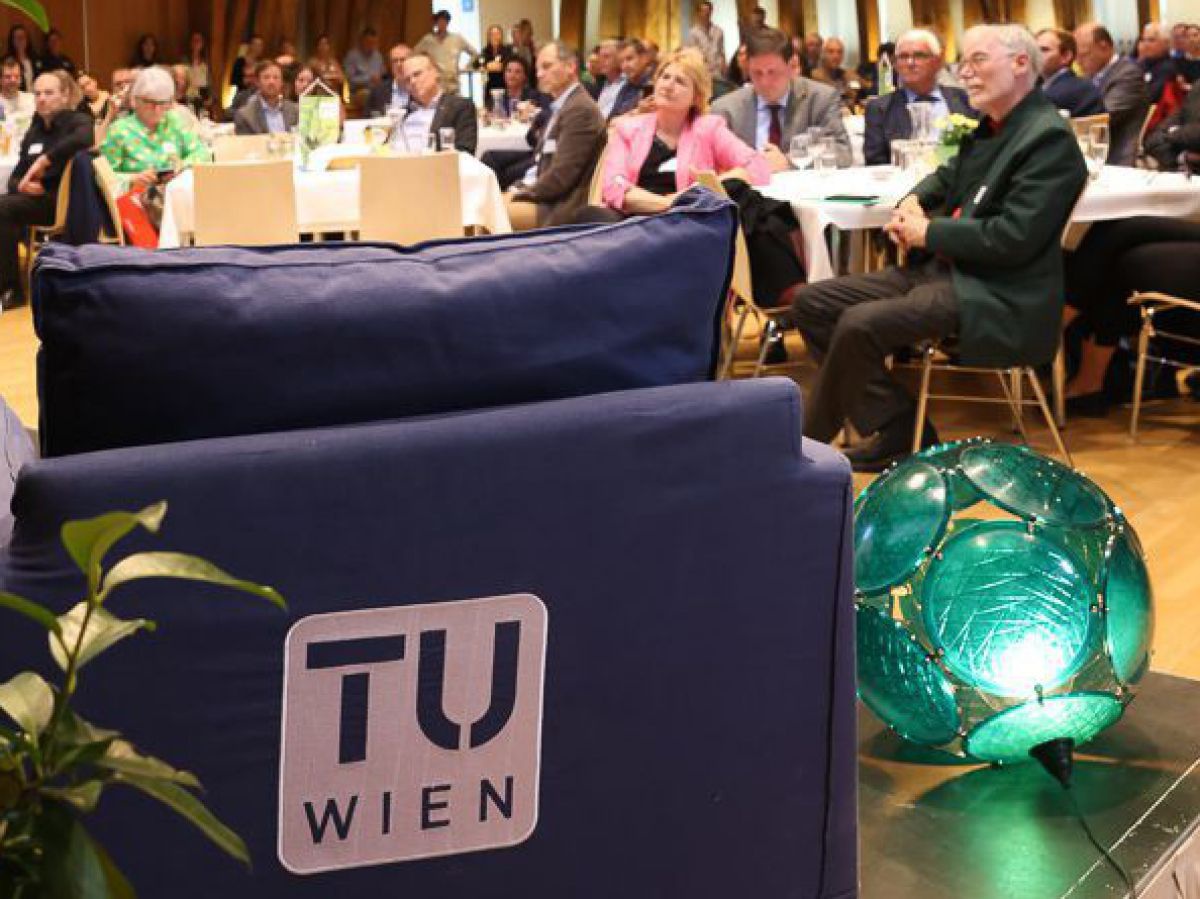 Blick von seitlich hinter der Bühne in der TU Wien auf das Publikum bei der Preisverleihung.