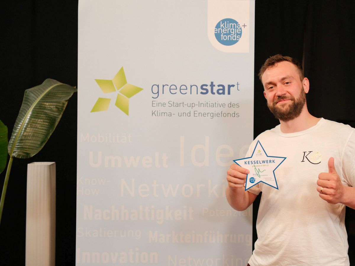 Foto vom greenstar(t) Kick-Off-Event 2023, Felix Billiani von Kesselwerk auf der greenstar(t)-Bühne, er hält einen Papierstern in die Kamera und zeigt 