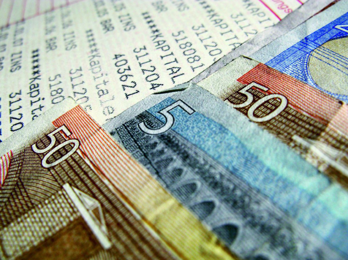 Euro-Geldscheine liegen neben einem Kontoauszug