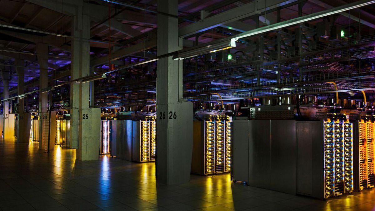 Google Rechenzentrum in Hamina von innen: Eine riesige Halle, lange Reihen von Serverkästen mit Leuchtdioden in verschiedenen Farben, nach oben hin verkabelt zu Kabeltunnel an der Decke.