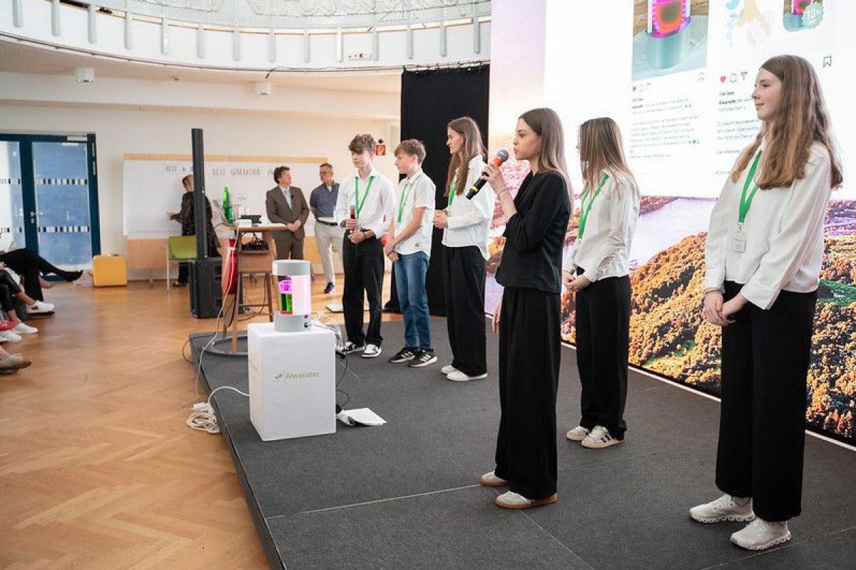 Junge Entrepreneurs auf der Bühne bei der Präsentation ihres Projekts.