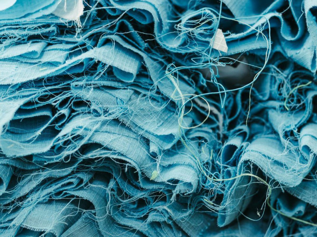 Hellblaue Textilfasern und Stoffreste, die das gesamte Bild ausfüllen