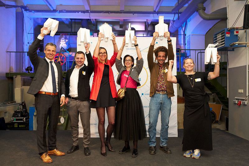  Gewinner*innen TRIGOS 2025 bei der Fala mit den Awards in Jubelpose: Christian Schäfer (Laufen Austria GmbH), Lukas Fleisch (Rhomberg Bau GmbH), Nadina Ruedl (Die Pflanzerei), Verena Riedler (crowd4projects GmbH), Niko Bogianzidis (öKlo GmbH), Maria Koll