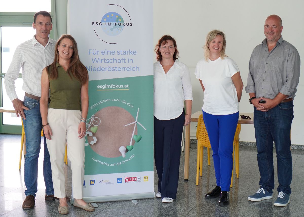 Zwei Männer und drei Frauen haben sich neben einem Rollup für ein Foto zusammengefunden. Auf dem Rollup steht: 