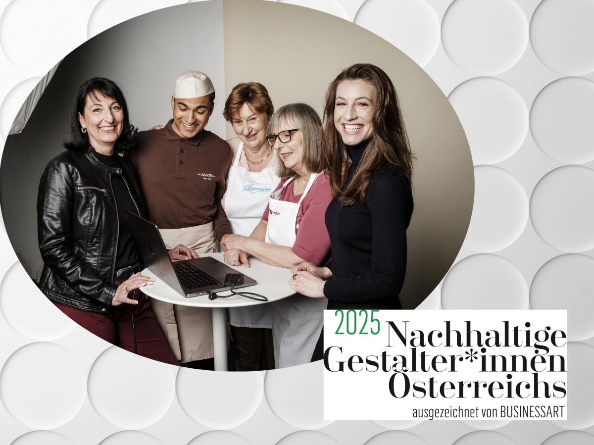 Vier Frauen und ein Mann sind um einen runden Stehtisch versammelt, auf dem ein aufgeklappter Laptop steht. Zwei älteren Frauen tragen Kochschürzen, der junge Mann eine Kochmütze und Schürze. Das Foto ist in einem ovalen Rahmen auf einem weißen, reliefart