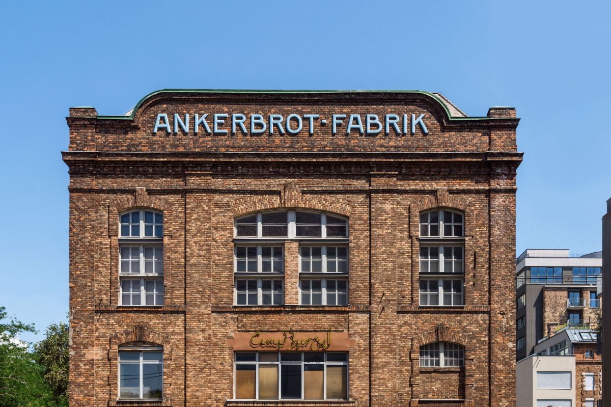 Die Backstein-Fassade der Ankerbrot-Fabrik in Wien, frontal von vorne aufgenommen mit dem Schriftzug in der Mitte.