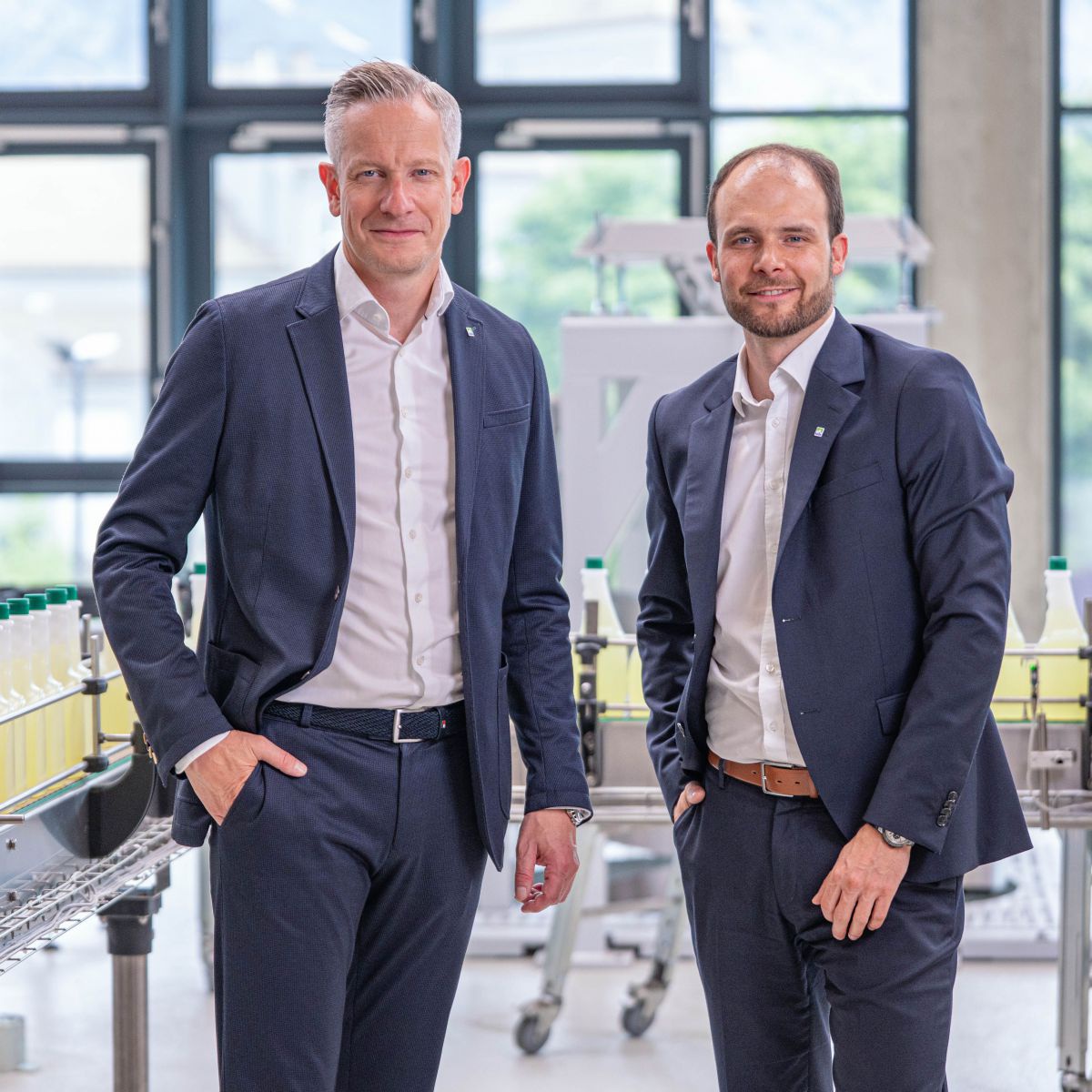 Die neue Doppelspitze bei hollu Systemhygiene, Markus Wendlinger und Udo Amann. Ein Dreiviertel Porträt in einer Halle im Unternehmen