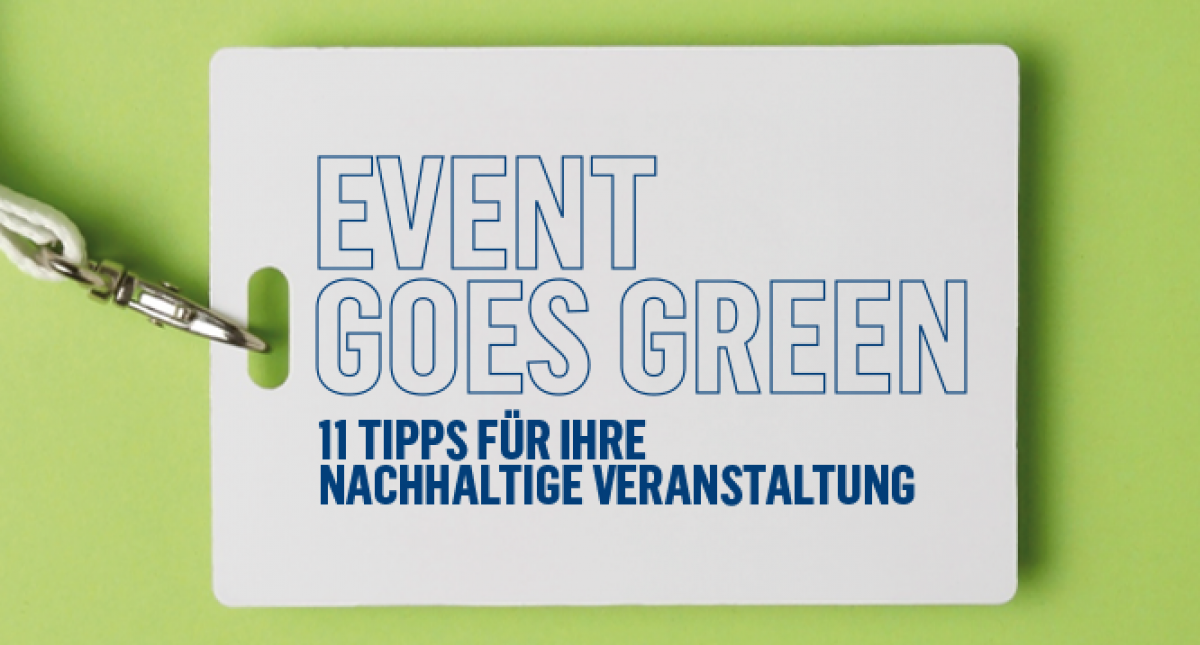 Auf hellgrünem Hintergrund liegt ein weißes Kärtchen, das an einem Lanyard (Umhängeband) hängt, darauf steht in blauer Schrift: EVENT GOES GREEN 11 Tipps für Ihr nachhaltige Veranstaltung