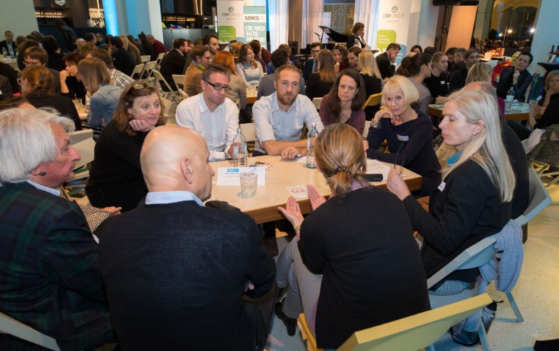 Menschen diskutieren am Tisch - Die Nachhaltigen GestalterInnen erzählen ihre Geschichte & Meilensteine