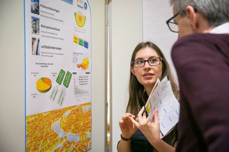 Ein junges Mädchen erklärt einem Mann eine Projektskizze